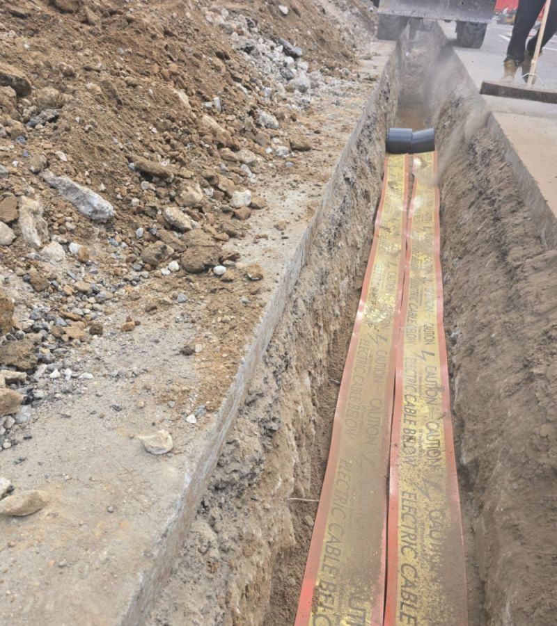 Open trench with electric cable warning tape