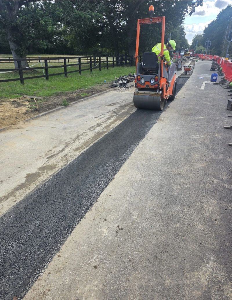 Roller compacting new surfacing on a carriageway