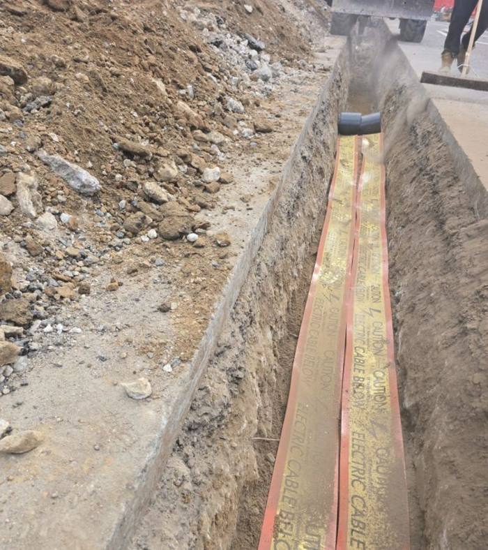 Open trench with electric cable warning tape